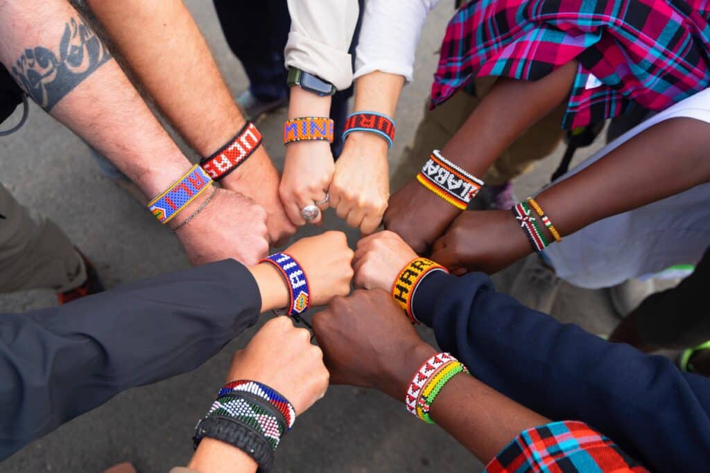 Participants and Samburu crew with beaded Samburu bracelets, hands together in a circle